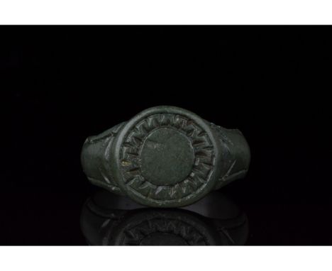 100-300 AD, Roman. Ring with circular loop, and raised round bezel bearing an incised decoration comprising a sun motif compr