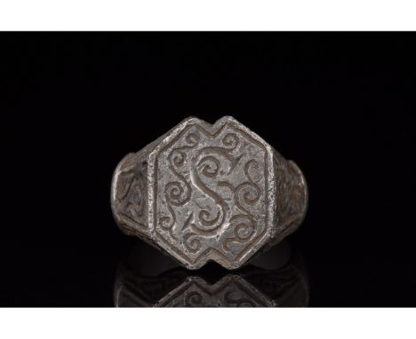 1100-1300 AD. Medieval. A heavy silver heraldic ring with a drop-shaped hoop and a hexagonal plate bezel with small triangula