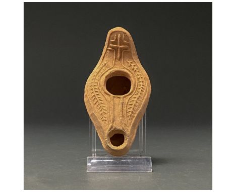 300-400 AD. Late Roman. A terracotta oil lamp a flattened, integral handle, bulging body and snub spout; a hole in the centre