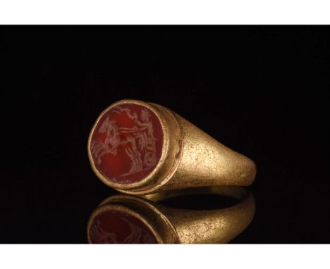 C. 100-300 AD. Roman. A gold ring with a circular hoop and round red gemstone intaglio depicting the god Apollo in a chariot 