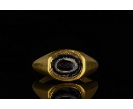 100-300 AD. Roman. Gold ring comprising a bow-shaped hoop with sloping shoulders and elliptical black glass â€œeyeâ€ setting 