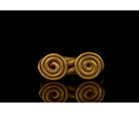 700-1100 AD, Viking Age. A gold coiled ring comprising a circular hoop formed from a strand of gold with coiled terminals and