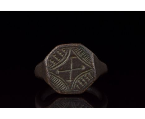 1000-1500 AD, Crusader Period. A bronze ring with a circular hoop and octagonal plate bezel bearing an engraved cross within 