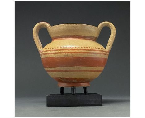 600-200 BC. Apulia. A Daunian terracotta jug with a flaring rim, carinated body, ring foot, and two high, ear-shaped handles.