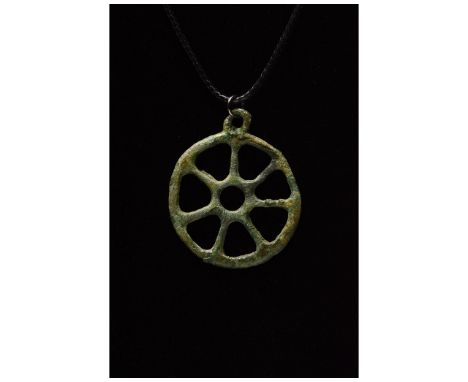Ca. 600 BC. Bronze Age. Bronze age wheel pendant comprising circular hoop and crossed spokes. In ancient societies, wheel amu