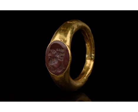 C. 100-300 AD. Roman. Gold ring comprising circular hoop and elliptical bezel with a carnelian setting. The setting bears an 