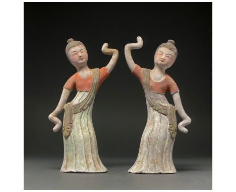 C. AD 618 and 907. Tang Dynasty. A pair of delicate Tang Dynasty dancers with long sleeves. Both dancers are wearing a long f