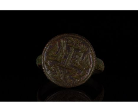 1100-1300 AD, Medieval. Ring with D-shaped hoop and flattened, round bezel featuring incised decorationof two facing dragons.