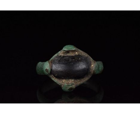700-1100 AD, Viking Age. Bronze ring with a circular hoop, and a lozenge shaped bezel onto which is mounted a large, oval dar