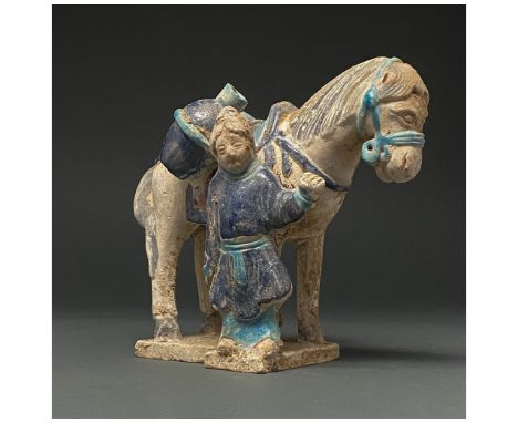 Ca. 1368-1644 AD. Chinese Ming Dynasty. Ceramic. This figurine shows a groom, dressed in a dark blue tunic, with light blue t