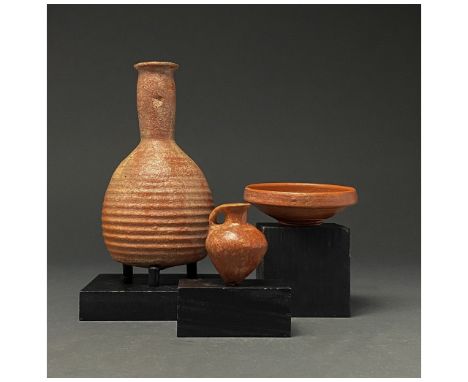 C. 300-400 AD. Late Roman. A collection of three terra sigillata vessels comprising (L-R): a large bottle with a flaring rim,