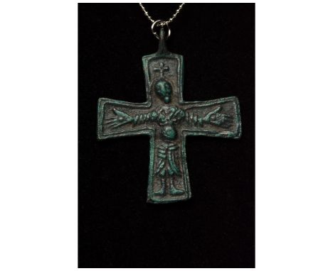 Ca. 1000 AD. Viking era. An early Scandinavian bronze cross pendant depicting a stylized Jesus Christ, dressed in a heavy rob