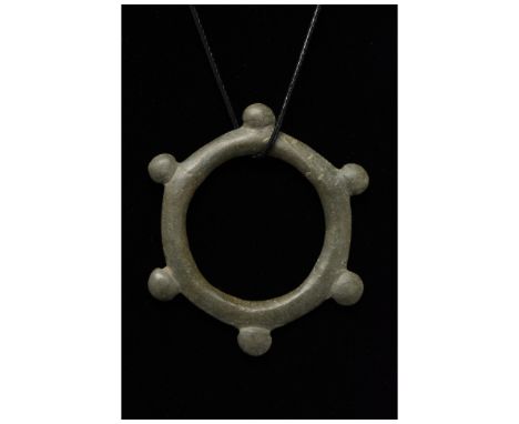 C. 600 BC, Bronze Age European. Openwork bronze sun pendant comprising a single large circle with raised decorative dots at r