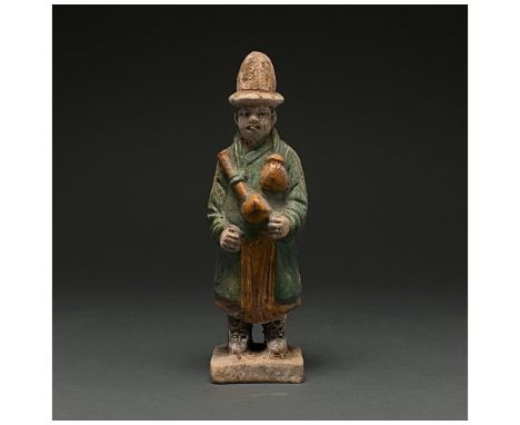 Ca. 1368-1644 AD. Chinese Ming Dynasty. An elaborately crafted male attendant figure dressed in a dark green tunic with orang