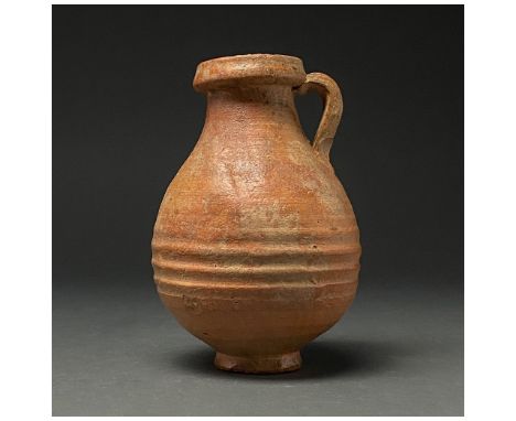 C. 100-300 AD. Roman. A terracotta jug with thick rim, piriform body and ring foot; a single strap handle connects at the bod