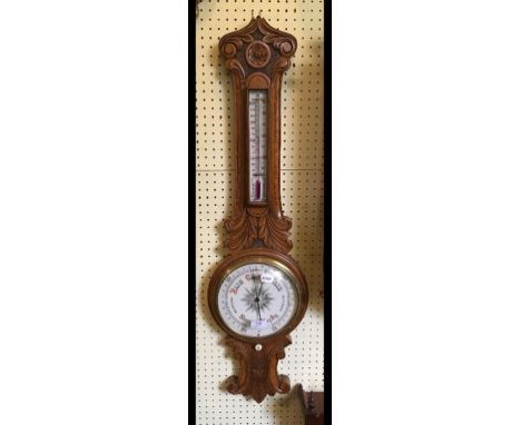 A barometer, with thermometer, in a carved oak case, 96 cm high