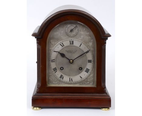 A mahogany mantel clock, the silvered dial with a chapter ring with Roman numerals and a Slow/Fast dial, signed Russells Ltd 