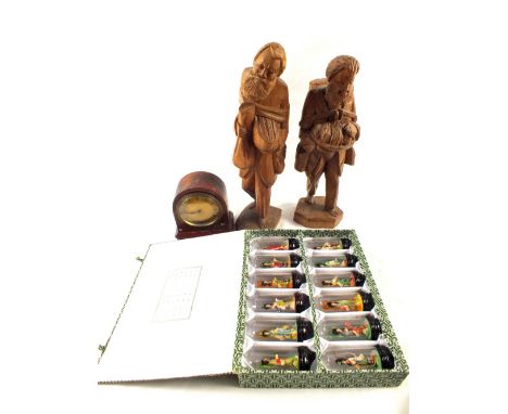 A pair of wood carvings of artisans, Chinoiserie mantel clock and a box containing twelve miniature Chinese Empresses under g