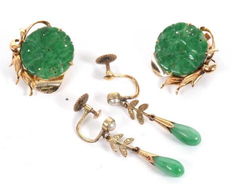 Two pairs of jade earrings, the first set with round, pierced discs of jade, approx. 16mm diameter, set with leaves and ribbo