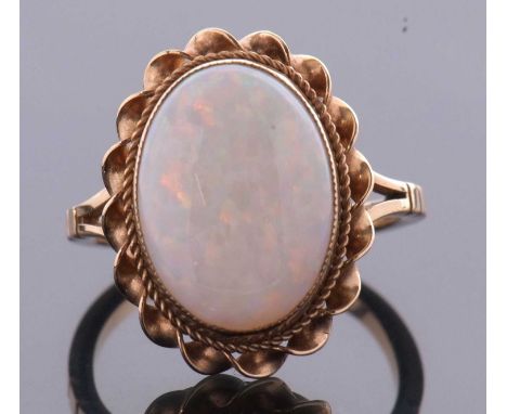 A 9ct opal ring, the oval opal cabochon, approx. 14 x 10mm, collet mounted with twisted border and plain band, Birmingham 197