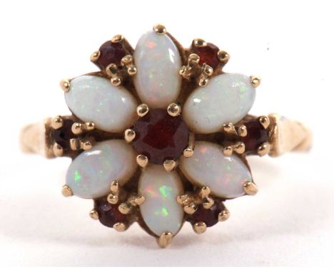 A 9ct opal and garnet flowerhead ring, the central round garnet surrounded by oval opal cabochons and small round garnets, wi