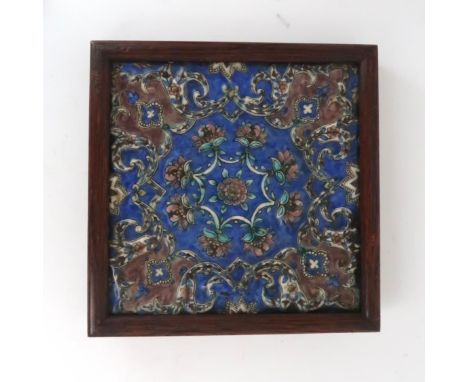 A PERSIAN POLYCHROME TILE Relief moulded and painted with flowers and scrolling foliage in green and blue, 23 x 23cm Conditio