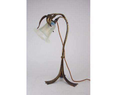 AN ARTS AND CRAFTS TABLE LAMP the gilded metal body with hammered decoration, and three leaves curling over the vaseline glas