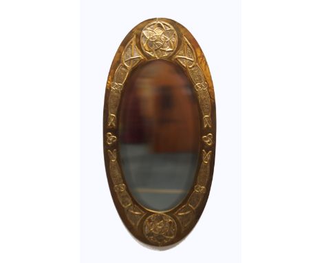 A GLASGOW SCHOOL CELTIC REVIVAL WALL MIRROR of oval form with knotwork decoration, 85cm long Condition Report:Available upon 