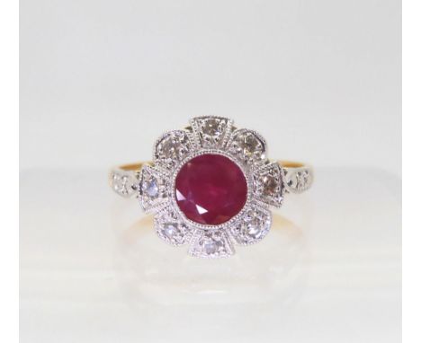 A VINTAGE RUBY AND DIAMOND RING set with a central ruby surrounded with eight cut diamonds, to a flower shaped mount, made in