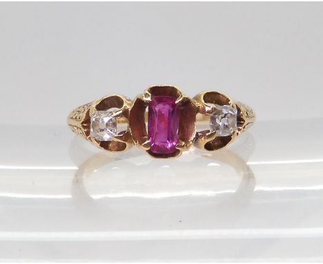 A VINTAGE THREE STONE RING set with two old cut diamonds and a mixed cut ruby in a scroll engraved setting, finger size K1/2,