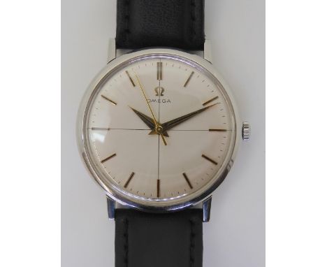 A VINTAGE OMEGA WRISTWATCH with a stainless steel case, brushed silvered cross hairs dial with gold coloured baton numerals a