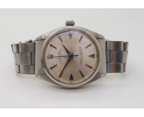 A ROLEX OYSTER PERPETUAL with stainless steel body and Oyster strap, silvered dial with chevron and arrow numerals, and dauph