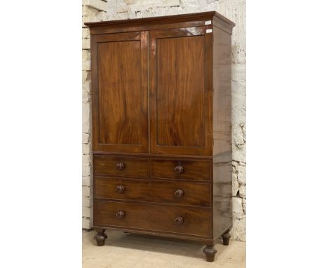 A Georgian mahogany linen press, first half of the 19th century, the projecting cornice above two fielded panelled doors with