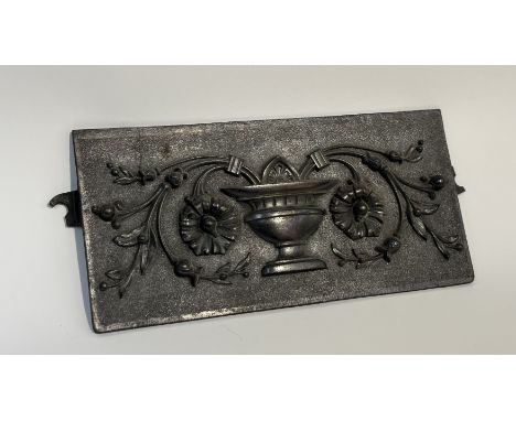 A cast-iron fire back plate with French style urn and foliate decoration. (h-16.5cm l-33cm)&nbsp;