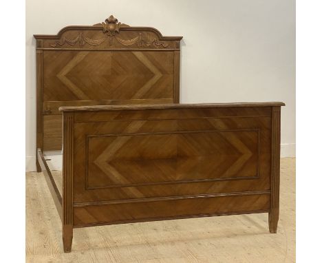 A French walnut and oak panel bed frame, circa 1900, the headboard carved with linen swags centred by a cartouche, with quart