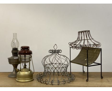 A group lot, comprising two wirework planters, a tilley lamp and an oil lamp, a brass and wrought iron trivet. (5)&nbsp;
