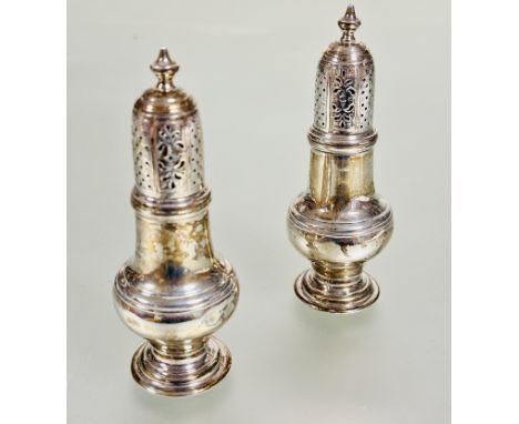 A pair of Victorian Birmingham silver pepperettes of Georgian style with urn finials and pierced and engraved tops of waisted