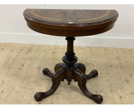 A Victorian walnut demi-lune card table, the fold over top inlaid with Greek key pattern border and opening to a baize lined 