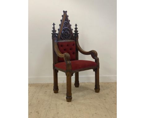 A Gothic revival oak ecclesiastical throne chair, late 19th century, the arched crest rail with cruciform surmount above a pa