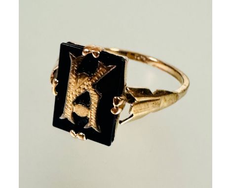 A 9ct gold cushion cut onyx panel signet style ring inset with letter K in four claw setting no signs of repairs or hard sold