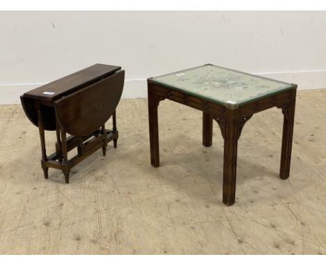 A mahogany coffee table, the glazed top inset with embroidered panel worked in a floral design and raised on blind fret carve