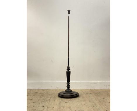 A well turned mahogany lamp standard, early 20th century, the water leaf carved finial above a ring turned and reeded column,