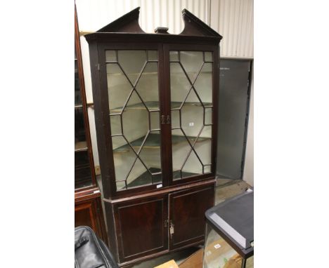George III Freestanding Corner Cabinet, broken arched pediment above two astragel glazed doors opening to two shaped shelves,