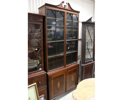 George III style Mahogany Inlaid and Crossbanded Bookcase, the tall upper section with a swan neck pediment and two glazed do