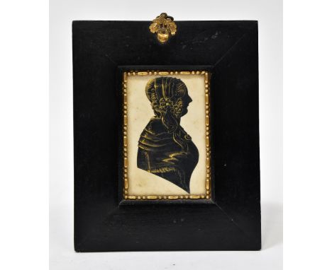 A 19th century black and gilt-highlighted silhouette portrait of a lady, mounted in a black lacquered frame, with ring hoop t