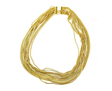 CHRISTIAN DIOR; a gold plated fourteen-strand necklace made up of various style chains, connected with hoop fastener, length 