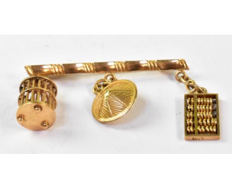 An 18K gold bar brooch in the form of bamboo, with three gold Oriental charms attached, comprising an abacus, straw hat and a