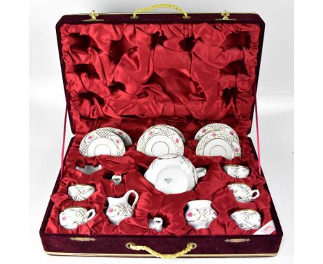A Güral porcelain tea service painted with springs of roses, gilt-heightened, contained within a burgundy velvet case.
