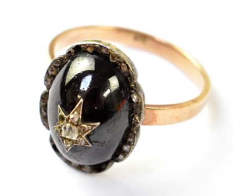 A Victorian 9ct gold ring with central half red stone cabochon, possibly ruby, with star set tiny diamond cluster (lacking on