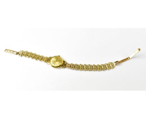 TISSOT; a ladies' vintage wristwatch, the gold circular dial set with raised baton numerals, a gold plated head and a later a
